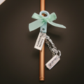 Copper straw with a mint green bow and charms on a dark background